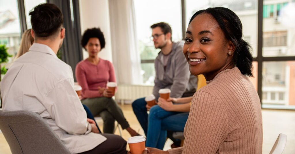 Photo of group dialogue with one young woman facing camera.